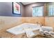 Close up of a jacuzzi tub with white towels on the side and a window above it at 9385 Mohawk St, Las Vegas, NV 89139