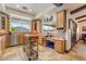 Eat-in kitchen with wood cabinets, stone counters, stainless appliances, travertine flooring, and a large garden window at 9385 Mohawk St, Las Vegas, NV 89139