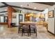Spacious kitchen with brick island, wooden beams, travertine flooring, and stainless steel appliances at 9385 Mohawk St, Las Vegas, NV 89139