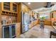 Well-lit kitchen featuring custom wood cabinetry, stainless steel appliances, stone countertops, and travertine flooring at 9385 Mohawk St, Las Vegas, NV 89139