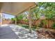 Spacious backyard features a covered patio, artificial turf, and mature trees at 9814 Gifthouse St, Las Vegas, NV 89178