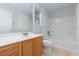 Bright bathroom features a large mirror, wooden vanity, and tiled shower/tub combo at 9814 Gifthouse St, Las Vegas, NV 89178