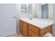 Bathroom featuring a wooden vanity with a white countertop, a large mirror, and tiled flooring at 9814 Gifthouse St, Las Vegas, NV 89178