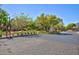 The gated entrance to the community features lush landscaping and a paver road at 9814 Gifthouse St, Las Vegas, NV 89178
