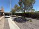 View of the backyard, featuring shade trees, gravel landscaping, and a covered patio area at , Las Vegas, NV 89145