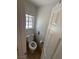 A compact powder room with a toilet and small window, illuminated by natural light at , Las Vegas, NV 89145