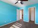 A bright blue bedroom features a ceiling fan, carpeted floors, and natural sunlight at 1012 Water Cove St, Henderson, NV 89011