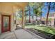 Inviting covered patio leading to a spacious backyard with mature trees and lush landscaping at 10198 Timber Willow Ave, Las Vegas, NV 89135