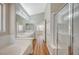 Bathroom showcasing a glass-enclosed shower, soaking tub, double vanity, and white tile at 10198 Timber Willow Ave, Las Vegas, NV 89135