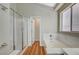 Bright bathroom showcasing a glass-enclosed shower, soaking tub, and white tile throughout at 10198 Timber Willow Ave, Las Vegas, NV 89135