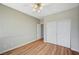 Well-lit bedroom featuring a closet, wood-look floors, and a ceiling fan at 10198 Timber Willow Ave, Las Vegas, NV 89135