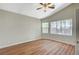Spacious bedroom with wood-look floors, neutral paint, ceiling fan, and large windows at 10198 Timber Willow Ave, Las Vegas, NV 89135