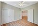 Well-lit bedroom with wood-look floors, ceiling fan, and closet with double doors at 10198 Timber Willow Ave, Las Vegas, NV 89135