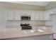 Close up of a kitchen with stainless steel appliances, an island, and white cabinets at 10198 Timber Willow Ave, Las Vegas, NV 89135