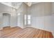 Inviting living room showcasing wood floors, decorative wall paneling, and modern chandeliers at 10198 Timber Willow Ave, Las Vegas, NV 89135