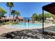 Community pool featuring a splash fountain, slide, and shaded lounge areas for relaxation at 10198 Timber Willow Ave, Las Vegas, NV 89135