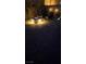 Night view of backyard fire pit, surrounded by pavers and desert landscaping at 10904 Ellis Pointe Ave, Las Vegas, NV 89166