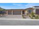 Charming home showcasing a three-car garage and well-maintained front yard with lush landscaping and beautiful hardscape at 10904 Ellis Pointe Ave, Las Vegas, NV 89166