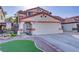 Charming home featuring a two-car garage, tile roof, desert landscaping, and a private courtyard entrance at 117 Lotus Blossom Ct, Las Vegas, NV 89145