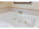 Close up of a bright, white drop-in bathtub with a tile surround, perfect for relaxation at 135 E Harmon Ave # 2116, Las Vegas, NV 89109
