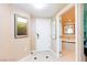 Hallway with art, a white painted door and tile flooring, leading to the bathroom at 135 E Harmon Ave # 2116, Las Vegas, NV 89109