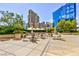 Charming outdoor patio with tables, chairs, umbrellas, plants, and views of the city skyline at 135 E Harmon Ave # 2116, Las Vegas, NV 89109