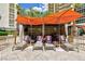 Inviting poolside lounge area with orange umbrellas, cushioned lounge chairs, and cozy cabana seating at 135 E Harmon Ave # 2116, Las Vegas, NV 89109