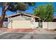 Street view of the home highlighting the two-car garage and gated front entry with lush landscaping at 1905 Plaza Del Padre, Las Vegas, NV 89102