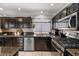 Beautiful kitchen with granite counters, dark cabinetry, and modern stainless steel appliances at 2042 Maple Springs St, Henderson, NV 89002