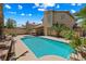 Backyard pool with patio, palm trees and desert landscaping on a sunny day at 2042 Maple Springs St, Henderson, NV 89002