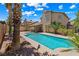Backyard pool with patio, palm trees and desert landscaping on a sunny day at 2042 Maple Springs St, Henderson, NV 89002