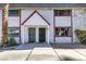 Two-story townhome featuring two front doors, white walls with red trim, and desert landscaping at 225 Pecos Way, Las Vegas, NV 89121