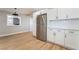 Modern kitchen with stainless steel refrigerator, white cabinets, and wood floors at 2749 Del Mar Pl, Las Vegas, NV 89169