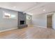 Spacious living room with a modern gray fireplace, two windows, and light wood flooring at 2749 Del Mar Pl, Las Vegas, NV 89169