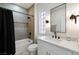 Modern bathroom featuring a shower over tub, black shower curtain, and vanity with black faucet at 2755 Darby Falls Dr, Las Vegas, NV 89134