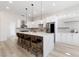 Modern kitchen featuring white cabinets, stainless steel appliances, and a waterfall island with bar seating at 2755 Darby Falls Dr, Las Vegas, NV 89134