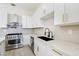 Modern kitchen with white cabinets, stainless steel appliances, and quartz countertops and black hardware at 2755 Darby Falls Dr, Las Vegas, NV 89134