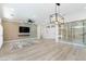 Open-concept living area featuring a large TV, modern lighting, and a glass-enclosed wine rack at 2755 Darby Falls Dr, Las Vegas, NV 89134