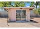View of a small structure with a large glass sliding door, surrounded by desert landscaping and privacy fencing at 2821 Moon Cir, Las Vegas, NV 89120