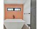Stylish bathroom featuring a modern soaking tub with orange backsplash tile and black fixtures at 324 Park Way, Las Vegas, NV 89106