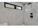 Modern shower with gray tiled walls, black hardware, and a narrow horizontal window at 324 Park Way, Las Vegas, NV 89106