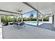 Covered outdoor dining area overlooking the pool with ceiling fans and modern furniture at 324 Park Way, Las Vegas, NV 89106