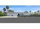 Beautiful single-story home boasts a well-manicured front yard, an iron fence, three-car garage, and a modern design at 324 Park Way, Las Vegas, NV 89106