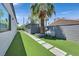 Side yard featuring artificial grass and stone pavers, offering a clean and modern look at 324 Park Way, Las Vegas, NV 89106