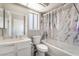 Bright bathroom featuring a marble tiled shower, tub, toilet, and a white single sink vanity at 327 Fuente Dr, Henderson, NV 89014