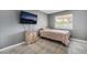 Cozy bedroom with light gray walls, tile floor, a window, and a TV mounted on the wall at 327 Fuente Dr, Henderson, NV 89014