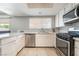 Bright kitchen with white cabinets, stainless steel appliances, and a tile backsplash, offering a clean and modern space at 327 Fuente Dr, Henderson, NV 89014