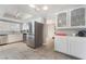 Well-lit kitchen featuring stainless steel appliances, tile floors, and white cabinets at 327 Fuente Dr, Henderson, NV 89014