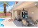 Backyard patio area with dining set next to sparkling pool and brick decorative features at 3495 Eagle Bend St, Las Vegas, NV 89122