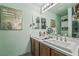 Well-lit bathroom featuring dual sinks, a large mirror, and modern fixtures for convenience and style at 3495 Eagle Bend St, Las Vegas, NV 89122